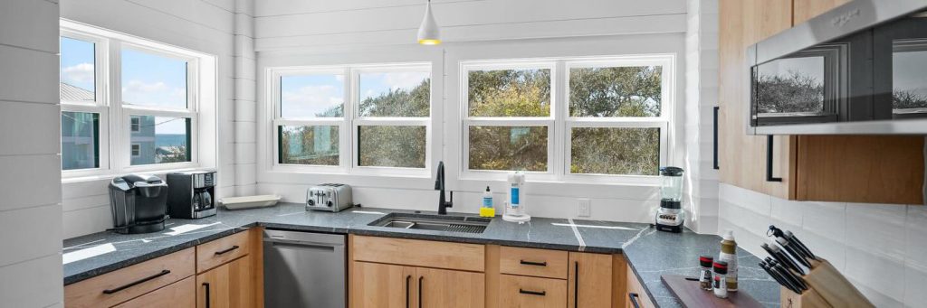 interior shot of kitchen with grey countertops and wood cabinets